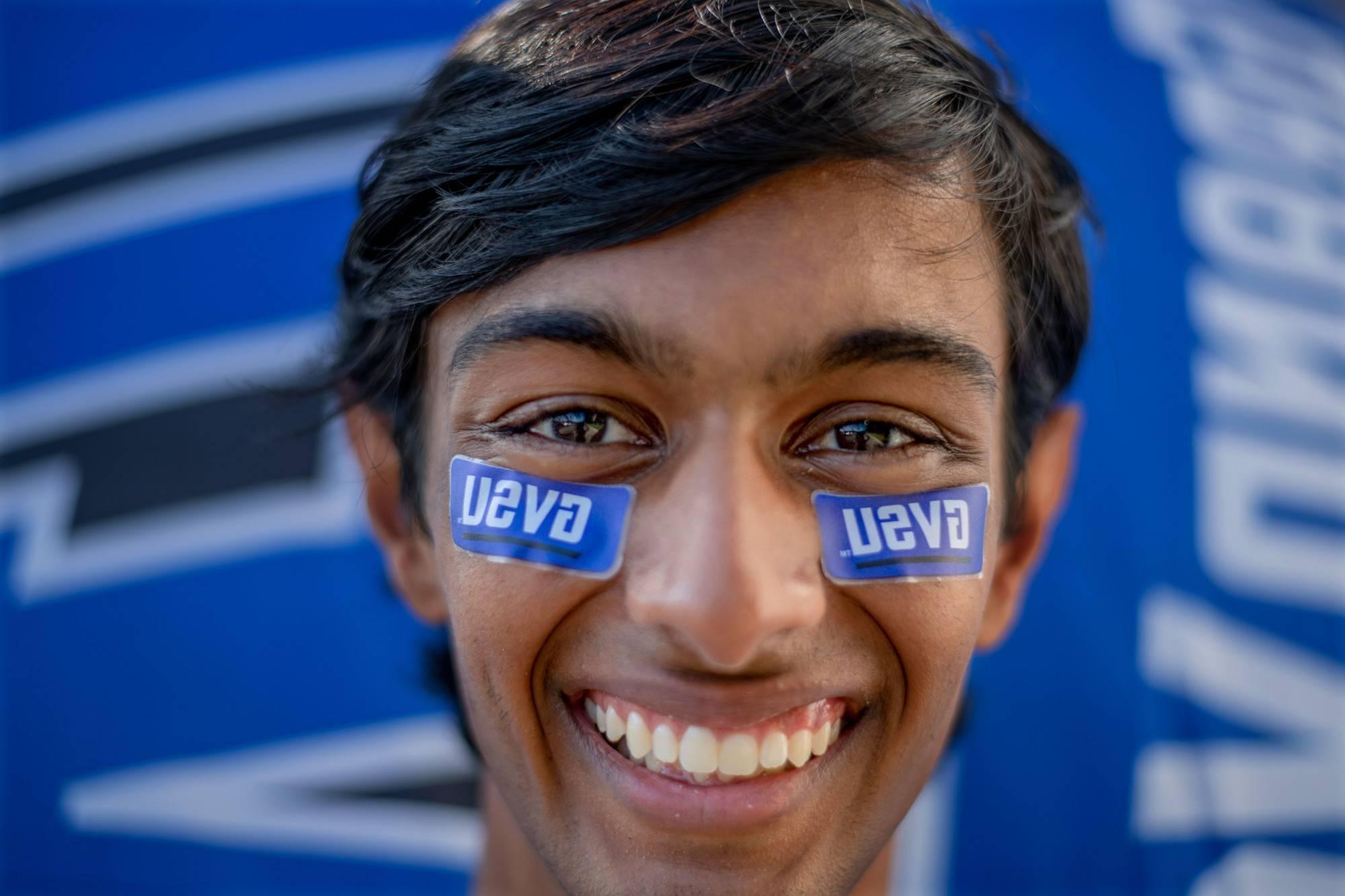 A student smiles with GVSU stickers on their face